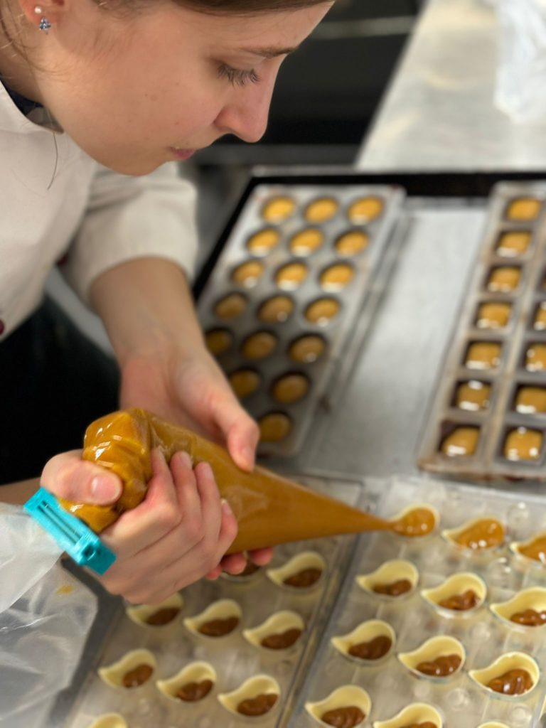 Pralinenherstellung bei Goldberg's Törtchen – Konditorin füllt handgefertigte Pralinen